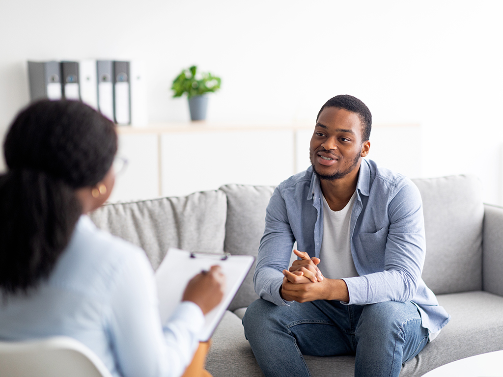 young-guy-talking-to-psychologist-at-mental-health-clinic